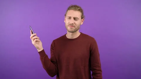 Portrait of a man talking on the phone on an isolated purple background. man Stock Footage 149037101