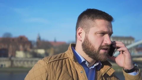 Portrait of man talking by smartphone and smiling at camera, close shot Vidéo 72709823
