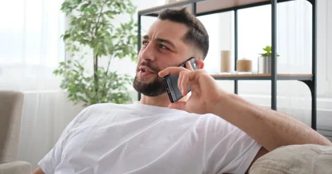 Portrait of man talking telephone on sofa at home Video stock 150025752