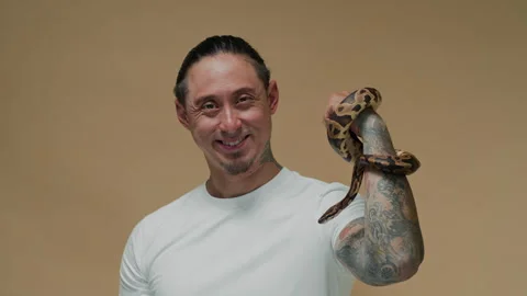 Portrait of Man with Tattoo on Arm Posing with Python Snake Stock Footage 302412088