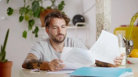 Portrait of man tiredly breathing checking important paper documents sitting at Stock Footage 108796238