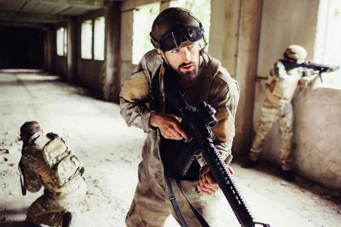 Portrait of man in uniform standing in empty room with other soldiers and Stock-Fotos