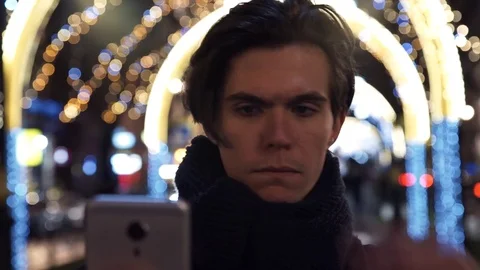 Portrait of man using app on smart phone at night in city Stock Footage 83630181