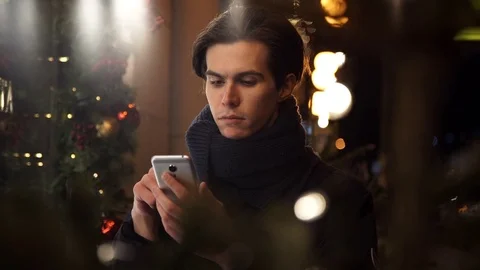 Portrait of man using app on smart phone at night city street near storefront Stock Footage 83630845