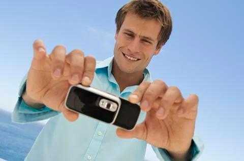 Portrait of a man using camera phone Stock Photos
