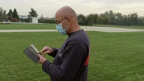 Portrait of Man Using a Smartphone at Garden While Wears a Medical Mask Stock Footage 141606258