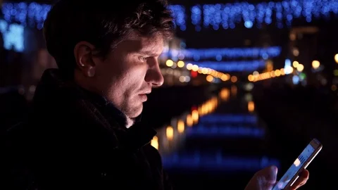 Portrait of man using smartphone standing alone outdoors at night on city street Stock-Footage 83629764