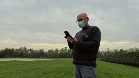 Portrait of Man Using a Smartphone While Wears a Medical Mask Stock Footage 141605933