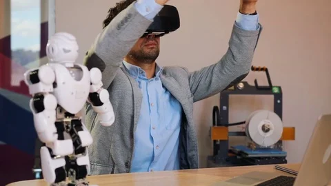 Portrait of man in VR glasses working on robot project in the urban white office Stock Footage 82498715