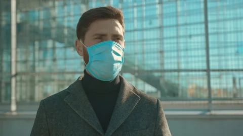 Portrait man wearing Protective Face Mask sneeze coughs hold suitcase COVID-19 Stock Footage 126581428