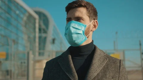 Portrait man wearing protective mask on street hold poster COVID-19 is a global Stock Footage 126584360
