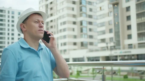 Portrait of a man in a white hat talking on the phone, takes off sunglasses Stock Footage 155389848