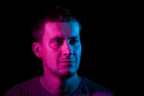 Portrait of a man whose head is turned to the side highlighted in pink and bl Stock Photos