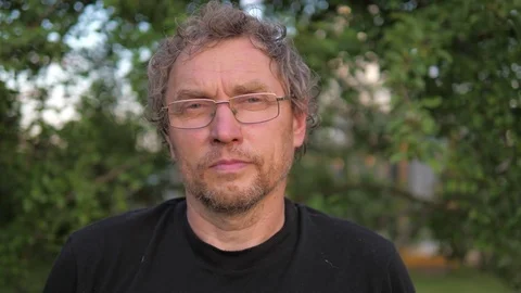 Portrait of a mature, attractive business man wearing glasses, looking at camera Stock Footage