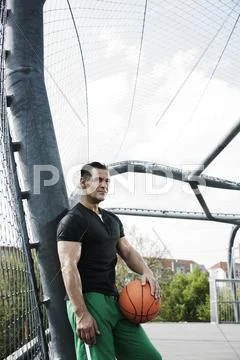 Portrait Of Mature Man Standing On Outdoor Outdoor Basketball Court, Germany