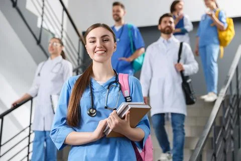 Portrait of medical student with books on staircase in college, space for tex Stock Photos
