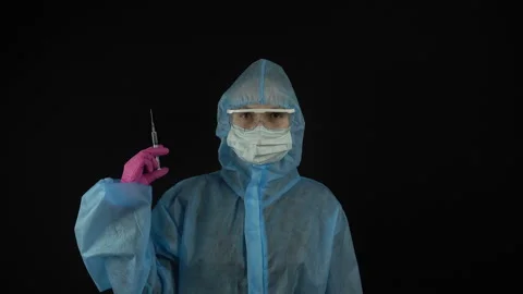 Portrait of a medical worker in a protective suit with a syringe in hand. Vaccin Stock Footage 129204553