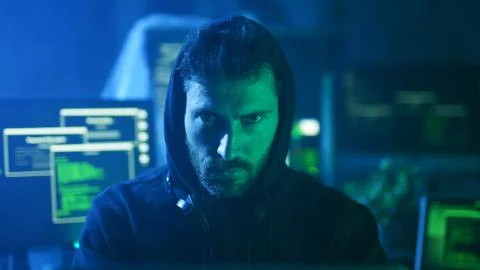 Portrait of menacing serious computer hacker working with codes on laptop at 스톡 사진
