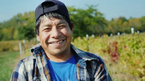 Portrait of a Mexican working farmer. Standing on the field, looking at the Stock Footage