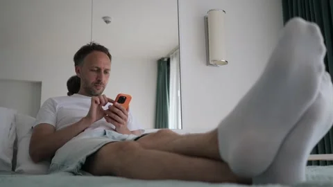 Portrait of middle aged businessman using phone in bedroom, texting message Stock Footage 261949555