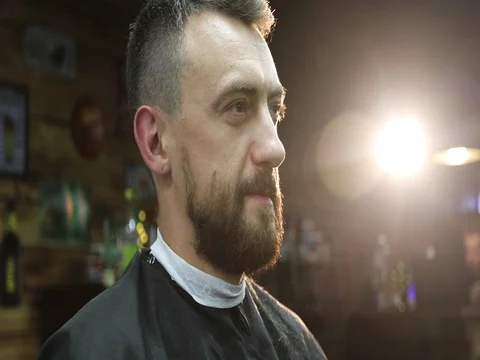 Portrait of the middle aged man in backlight at a barbershop. Stock Footage 80262496
