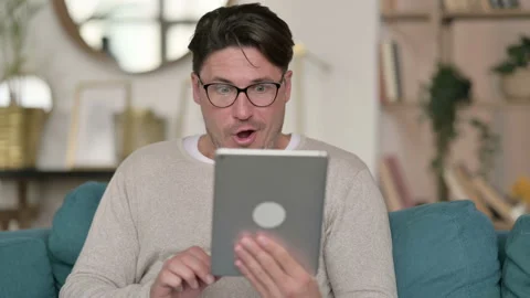 Portrait of Middle Aged Man Celebrating on Tablet at Home Stock Footage 142375166