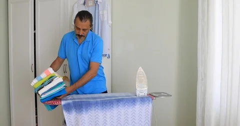 Portrait of middle aged man ironing clothes Stock Footage 93546148