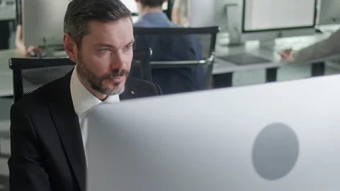 Portrait of Middle-Aged Man in Open Space Office Working on Decktop Computer Stock Footage 168683581