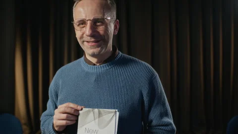 Portrait of Middle-aged Man Presenting Book with New Chapter Title Stock Footage 338046079