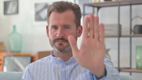 Portrait of Middle Aged Man with Stop Gesture Sitting at Home Video stock 287897486