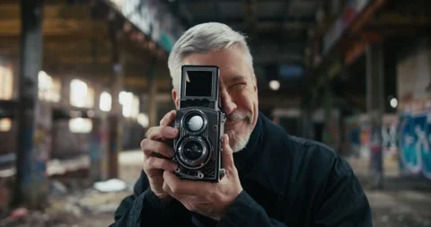 Portrait of middle aged man taking pictures with vintage camera Stock Footage 300797225