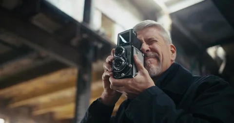Portrait of middle aged man taking pictures with vintage camera Stock Footage 300797264