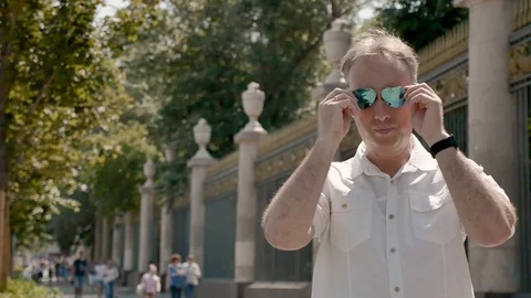 Portrait of a middle-aged man in a white shirt and sunglasses, with a black Video stock 112596797