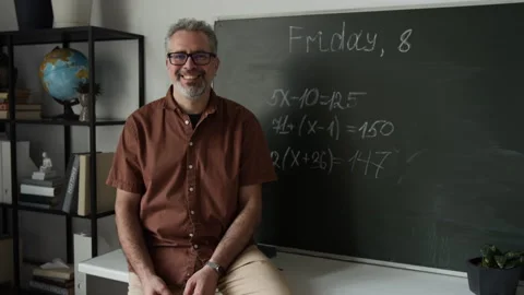 Portrait of Middle Aged Teacher Smiling during Math Lesson near Blackboard Stock Footage 339656905