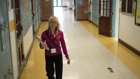 Portrait of a Middle-Aged Teacher Walking Down a School Hallway Stock Footage 296017953