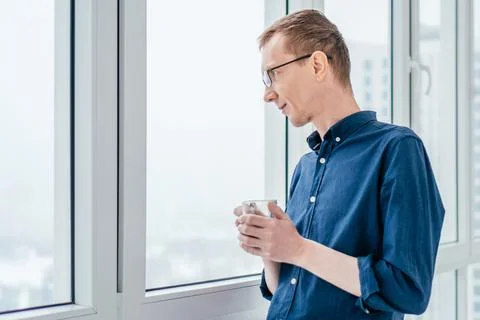 Portrait of middle-aged thin man with ginger hair and glasses in blue long Stock Photos