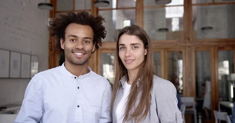 Portrait of mixed couple of students or colleagues in office open space Stock Footage 82679453