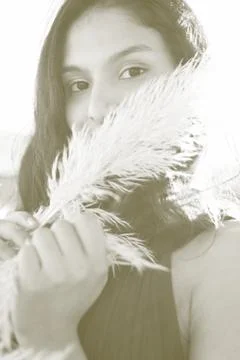 Portrait of model posing with Pampas grass in front of face. Selective focus. Stock Photos