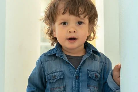 Portrait of modern little boy with long hair looking at camera Stock Photos