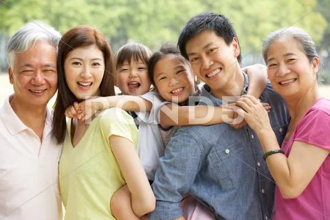Portrait of multi-generation chinese family relaxing in park together Stock Photos