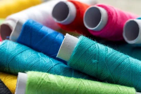 A portrait of multiple spools of thread lying on top of each other. Each roll Stock Photos