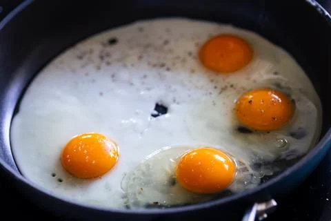 A portrait of multiple sunny side up eggs baking in a frying pan. The cook .. Stock Photos