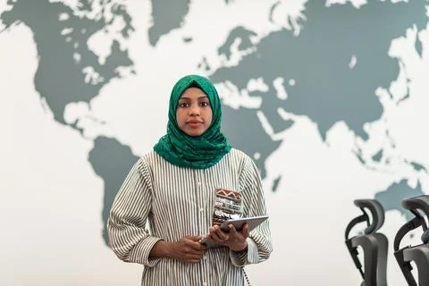 Portrait of muslim female software developer with green hijab holding tablet Stock Photos