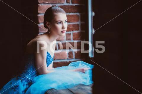 A portrait of a mysterious lady in a fluffy dress posing indoor on the window Stock Photos
