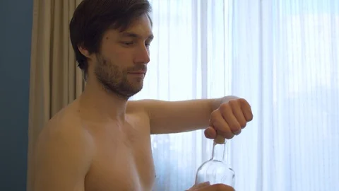Portrait of nake man drinking alcohol Stock Footage 129303469