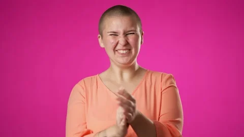 Portrait of non binary gender fluid woman 20s looks at camera rejoices clapping Stock Footage 223698531