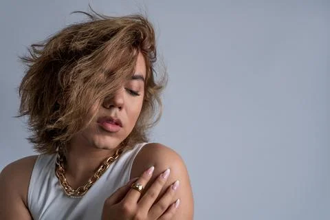 Portrait of non-binary young with long hair and cool style with calm attitude in Stock Photos