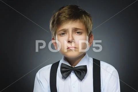 Portrait of offense crying boy isolated on gray background. Negative human Stock Photos
