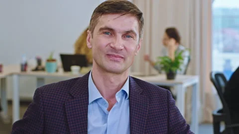 Portrait of a office manger at his work place looking straight to the camera and 스톡 동영상 132597570