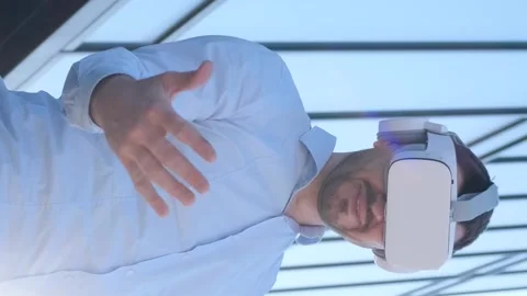 Portrait of an office worker wearing VR glasses, moving his hands in the air Stock Footage 250029517